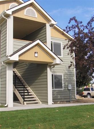 a green house with a yellow roof and stairs