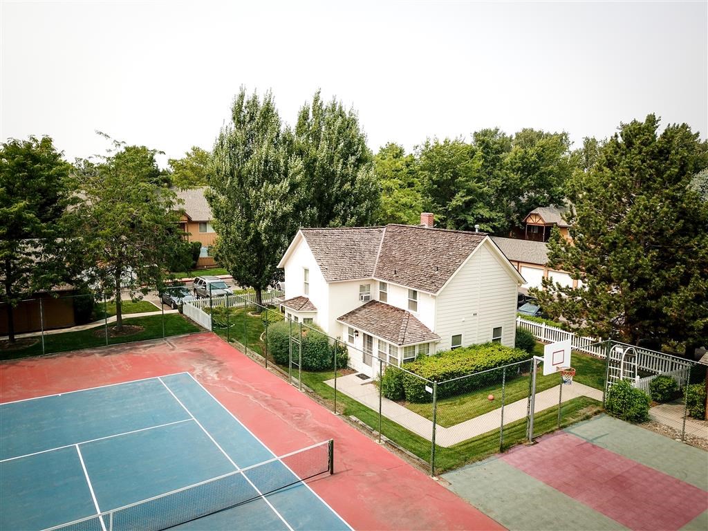 a tennis court in front of a white house