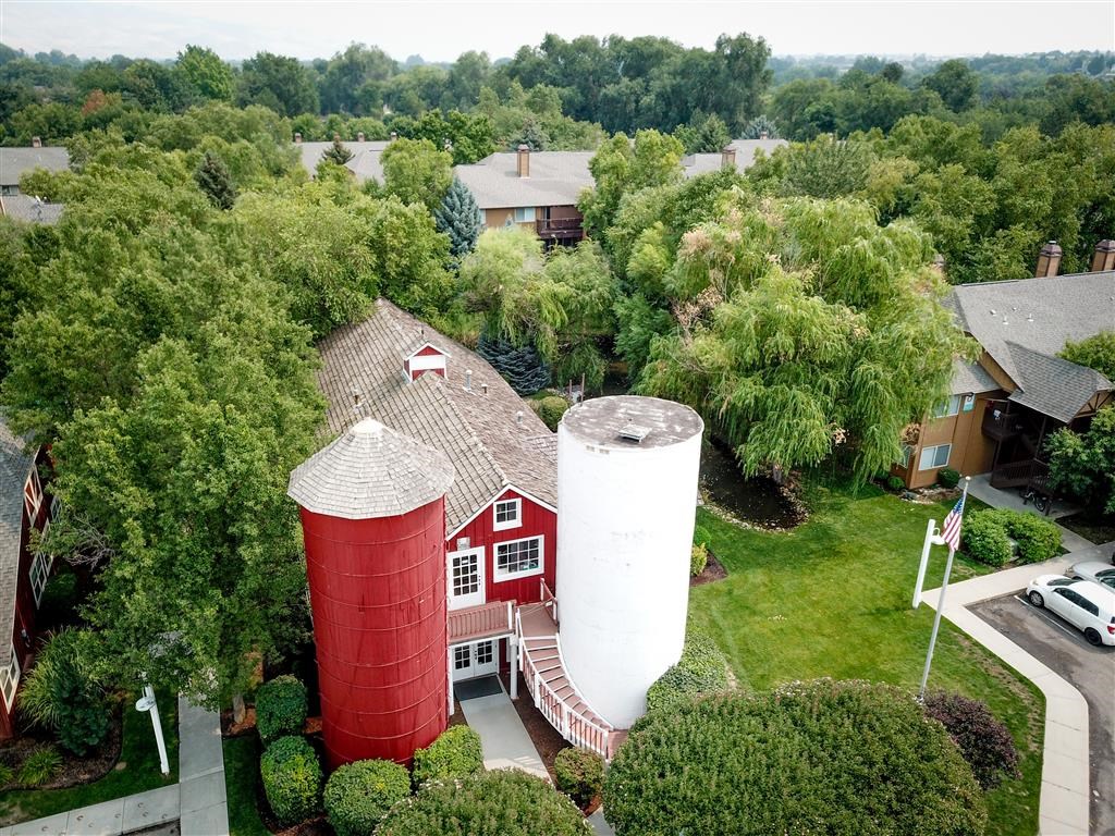 an aerial view of a red barn and two water towers