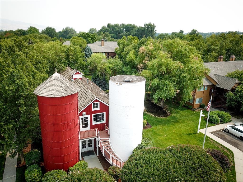 an aerial view of a farm house and two red water towers