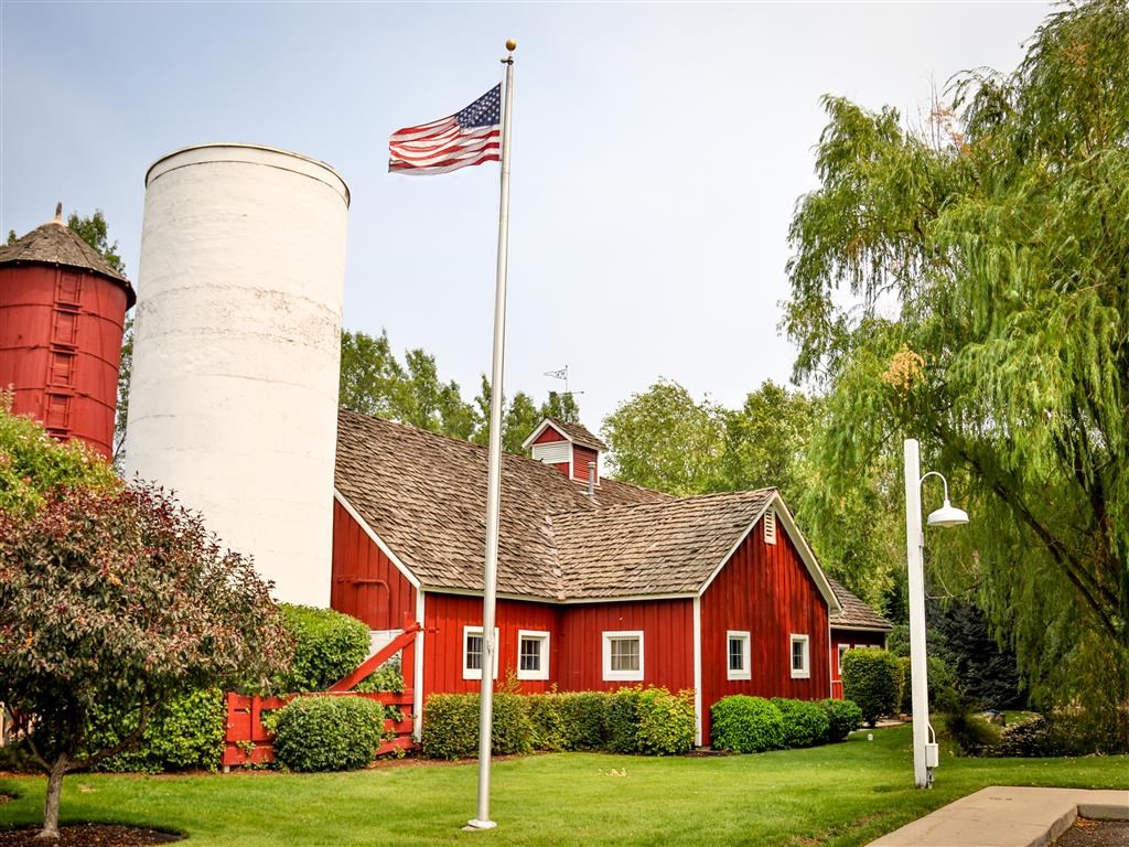 a red barn with an flag flying in front of it
