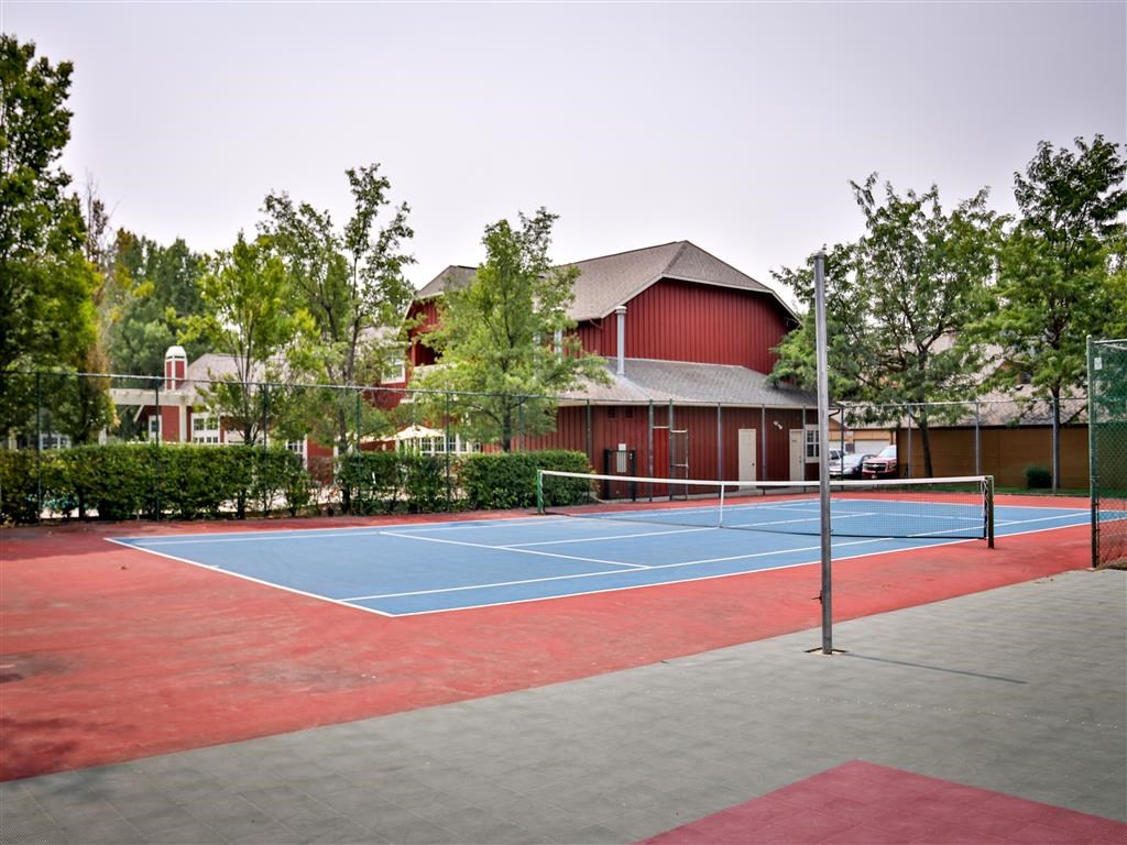 a tennis court with a house in the background