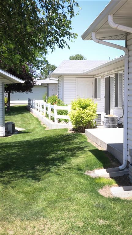 a row of houses with a lawn and a fence