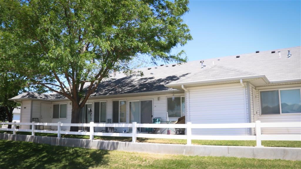 a white house with a white fence and a tree