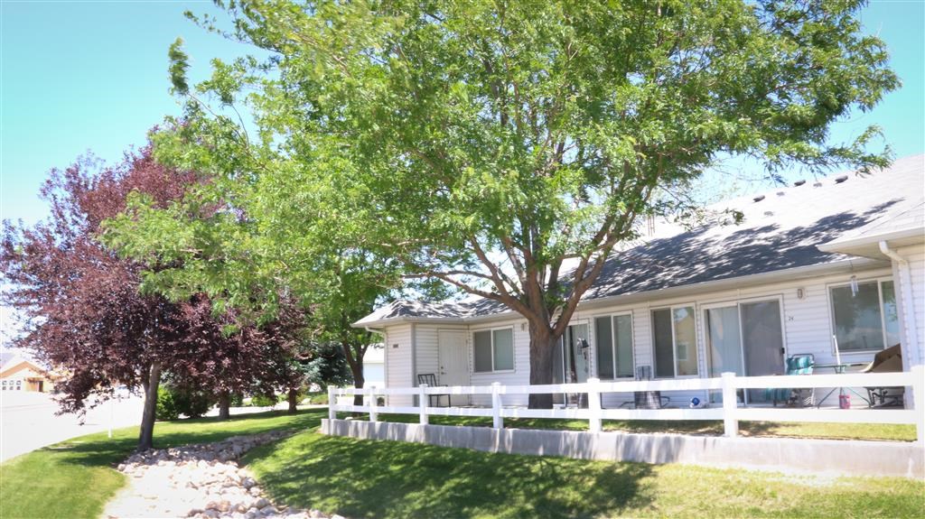 a white house with a white fence and some trees