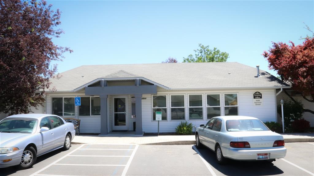 a white building with two cars parked in front of it