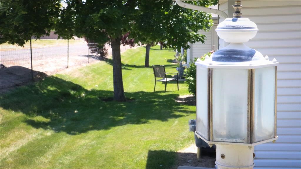 a white lantern sitting on the grass next to a house