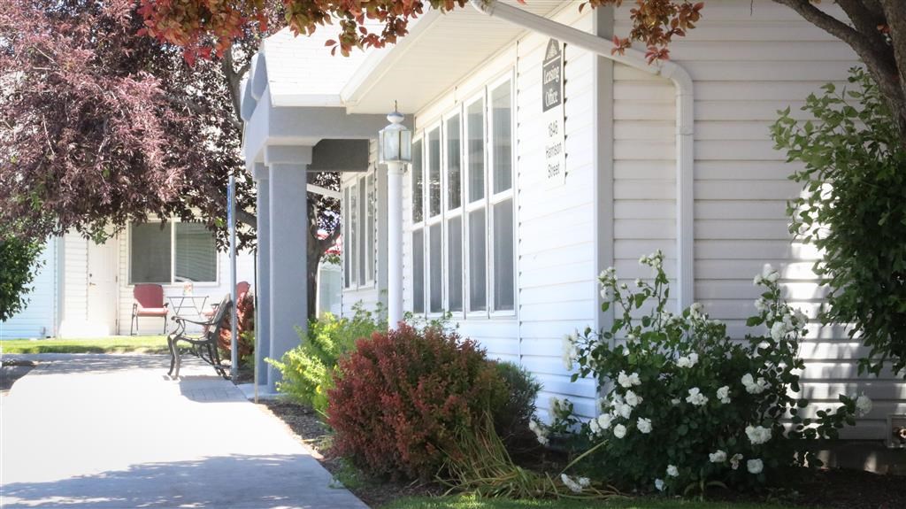 a white house with a porch and a sidewalk