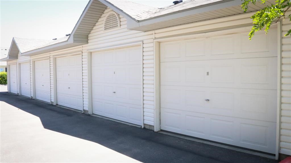 a row of white garage doors on the side of a house