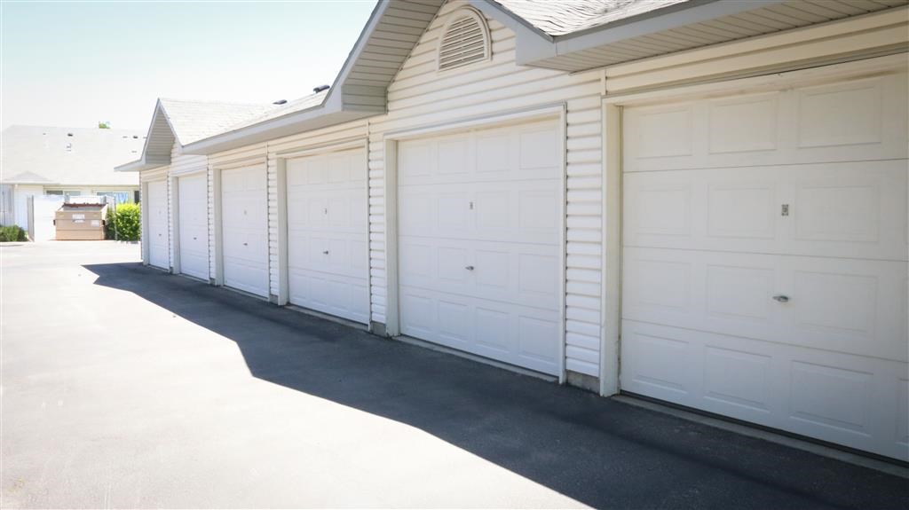 a row of white garage doors on the side of a house