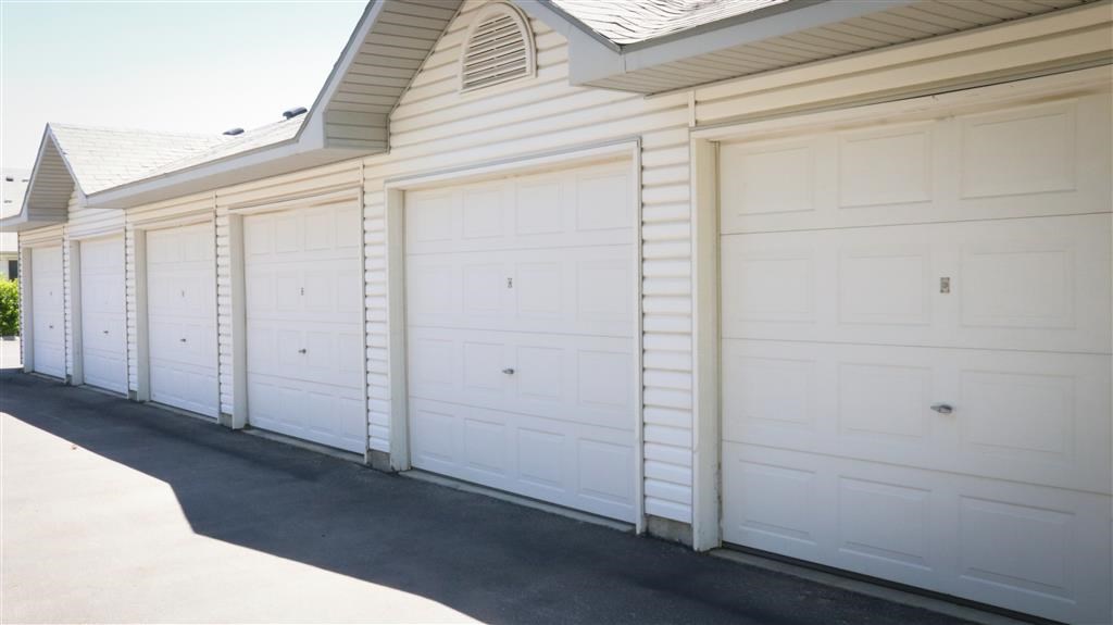a row of white garage doors on the side of a house