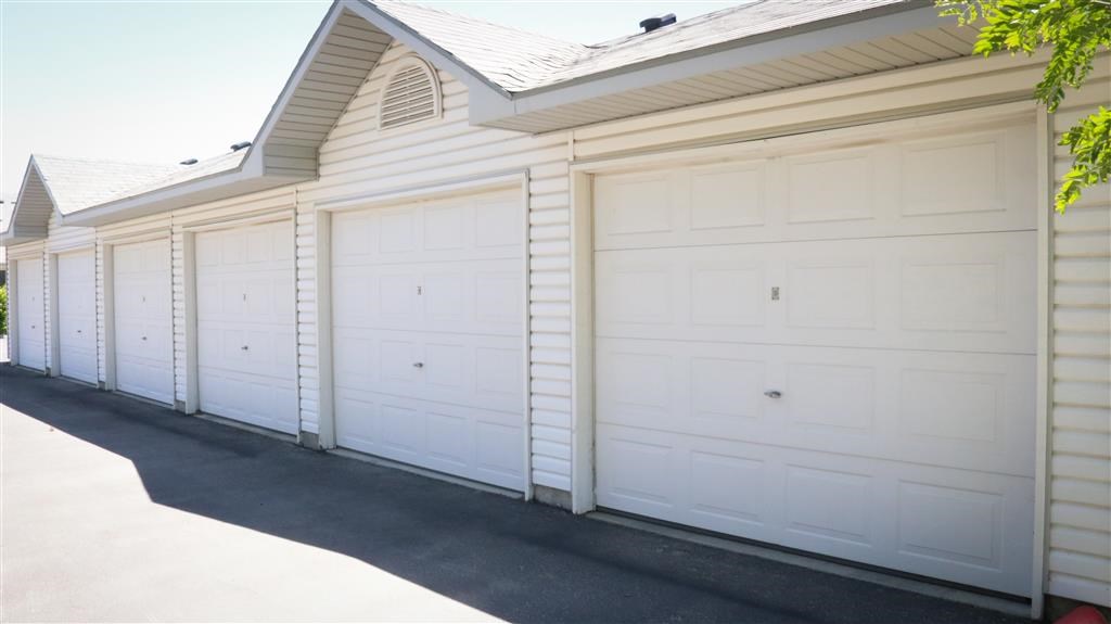 a row of white garage doors on the side of a house