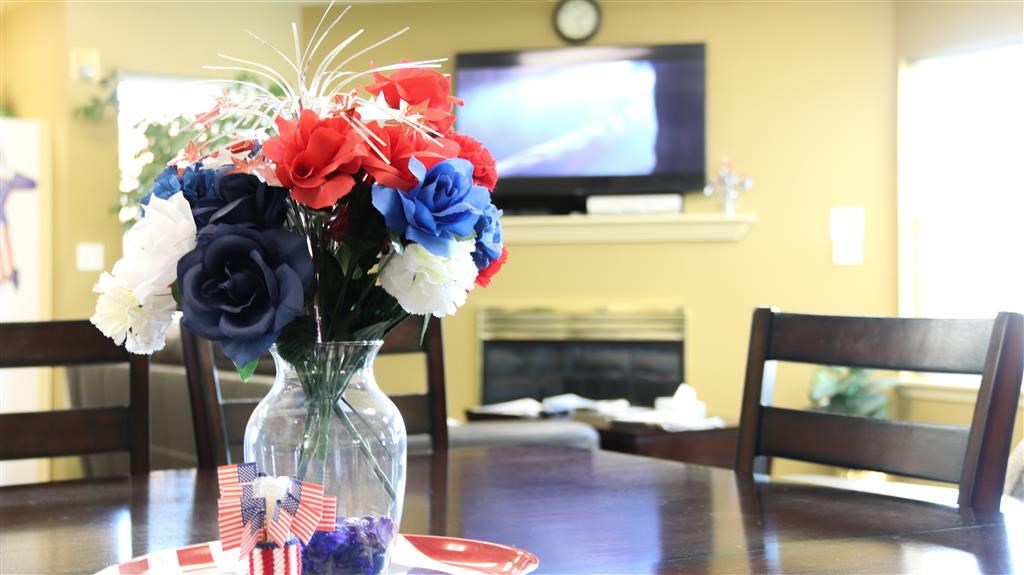 a vase with red white and blue flowers on a table