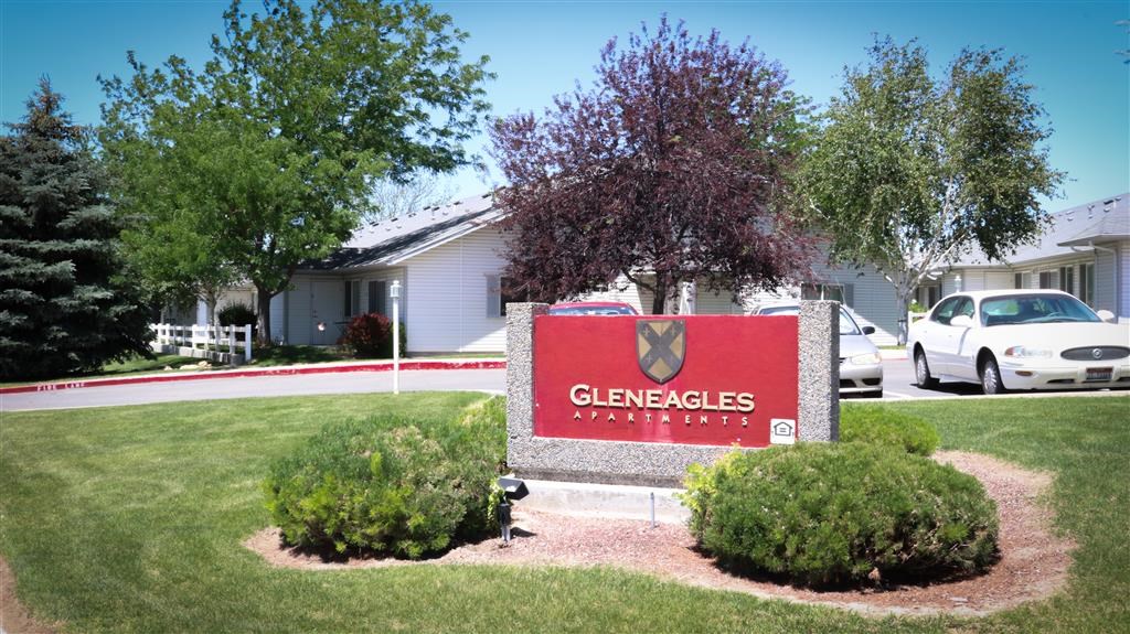 a sign in front of a building with a car in the driveway