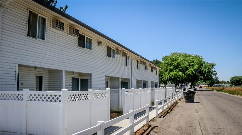 a white house with a white fence and a street