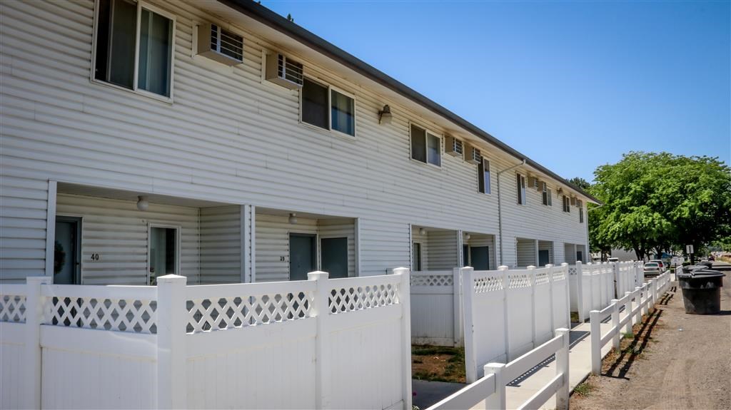 a white house with a white fence in front of it