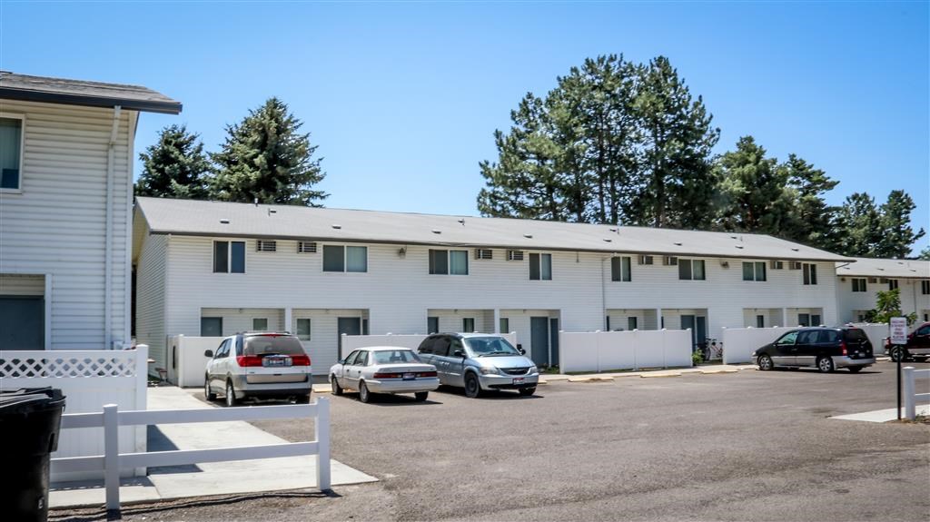 a large white building with cars parked in front of it