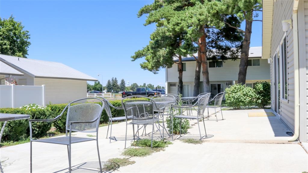 a patio with chairs and tables outside of a building