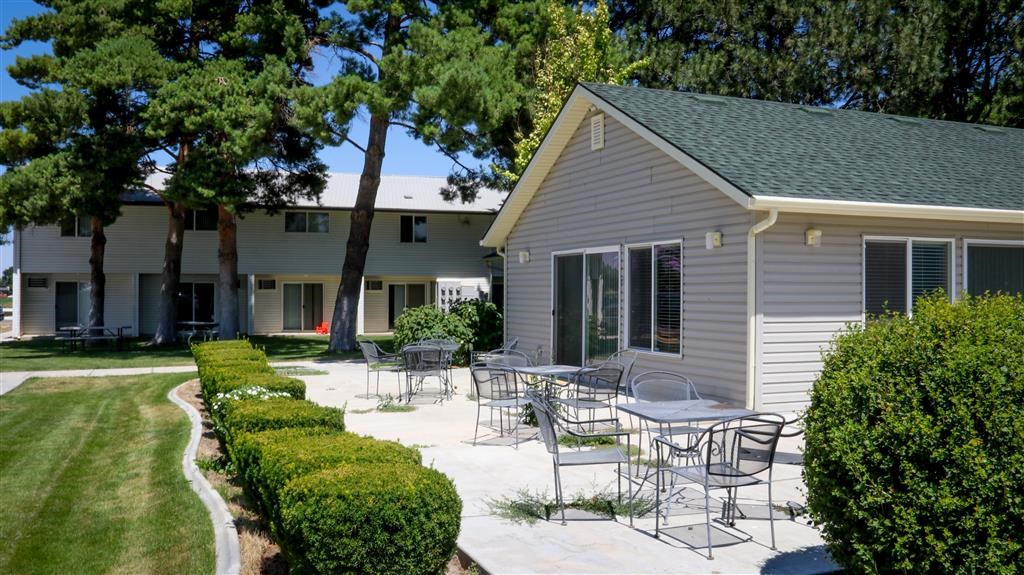a patio with tables and chairs in front of a building