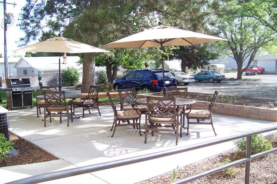 an outdoor patio with tables and chairs and umbrellas