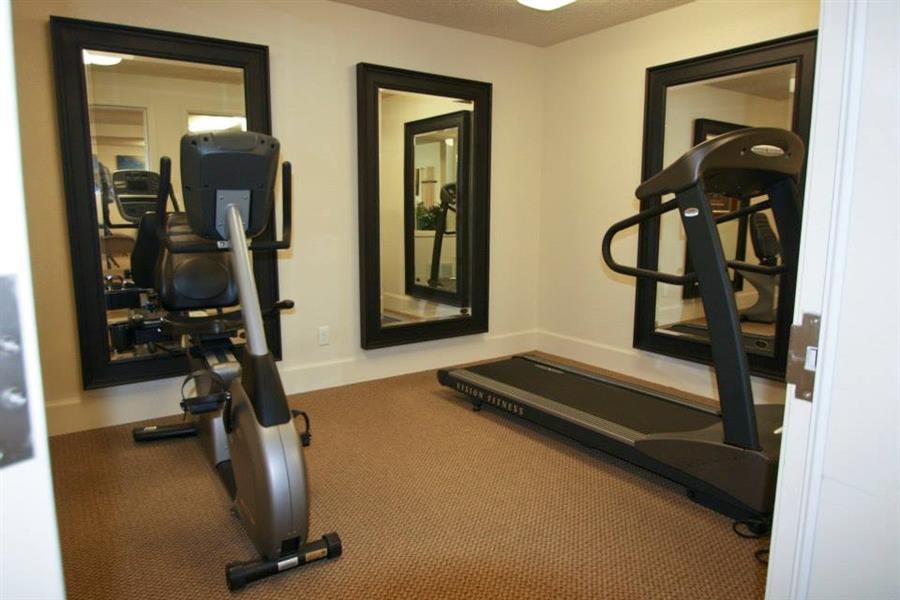 a workout room with a treadmill and mirrors