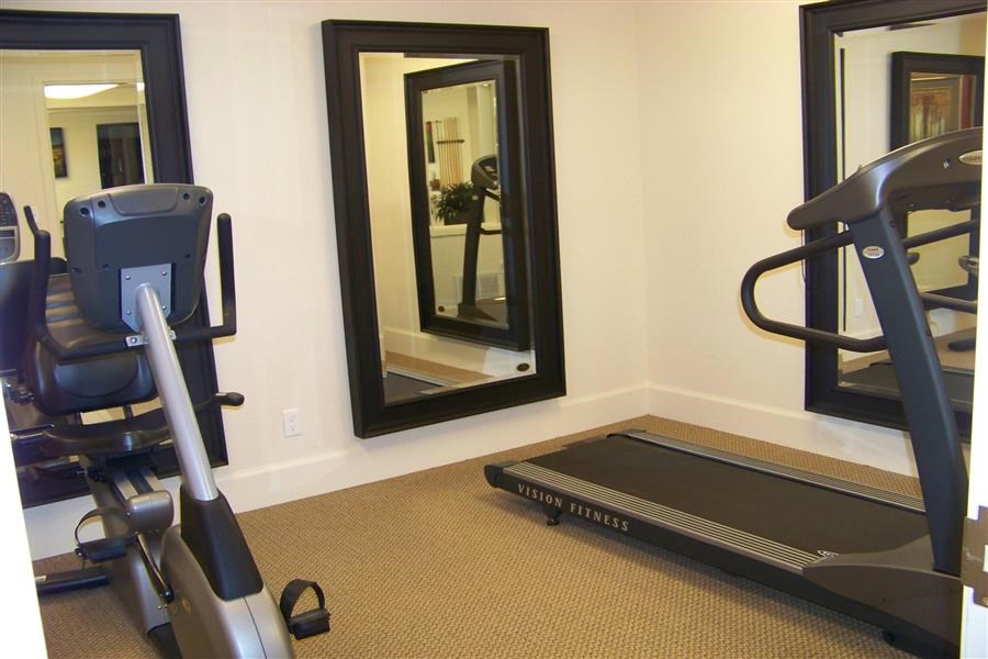a workout room with a treadmill and a mirror