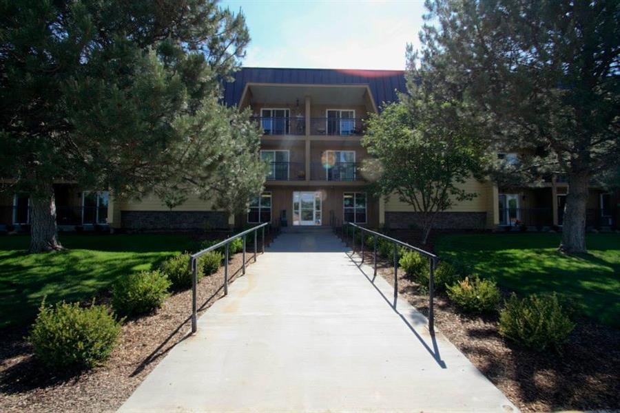 a large building with a white walkway and trees