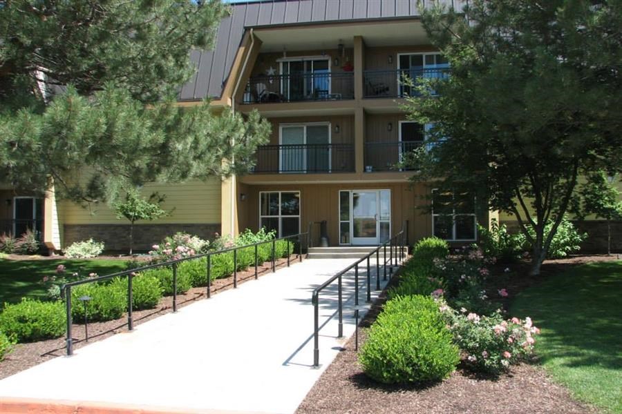 the front of an apartment building with a walkway and stairs