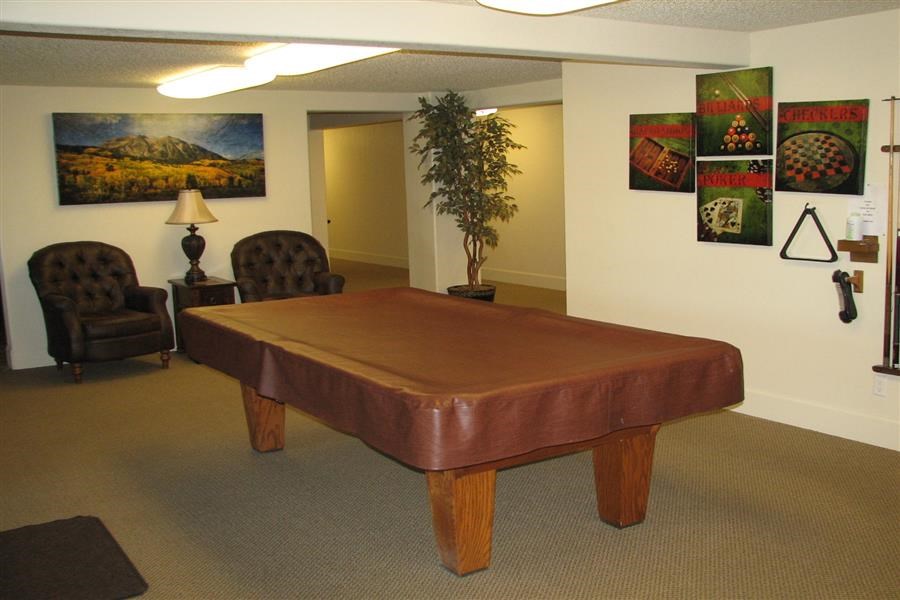 a living room with a leather pool table