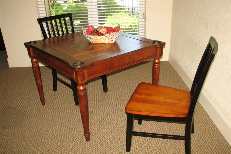 a table with two chairs and a bowl of fruit on it