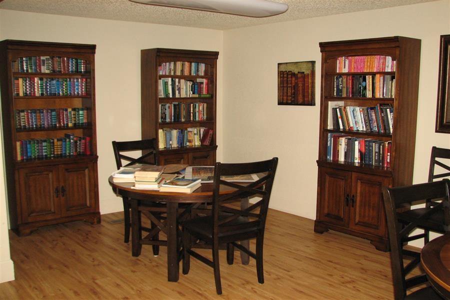 a library with a table and chairs and a book shelf