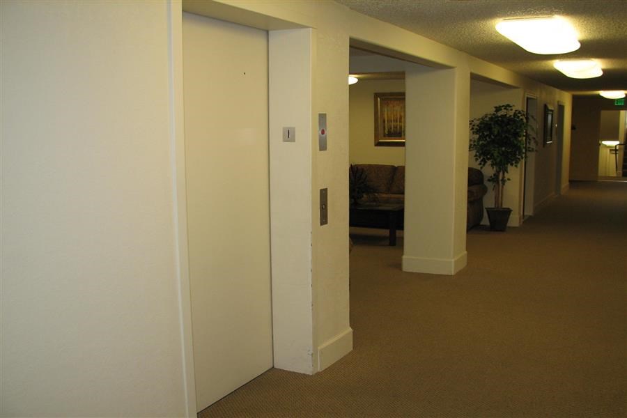 a hallway with white walls and a living room