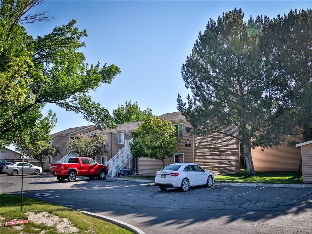 a row of houses with cars parked in a parking lot