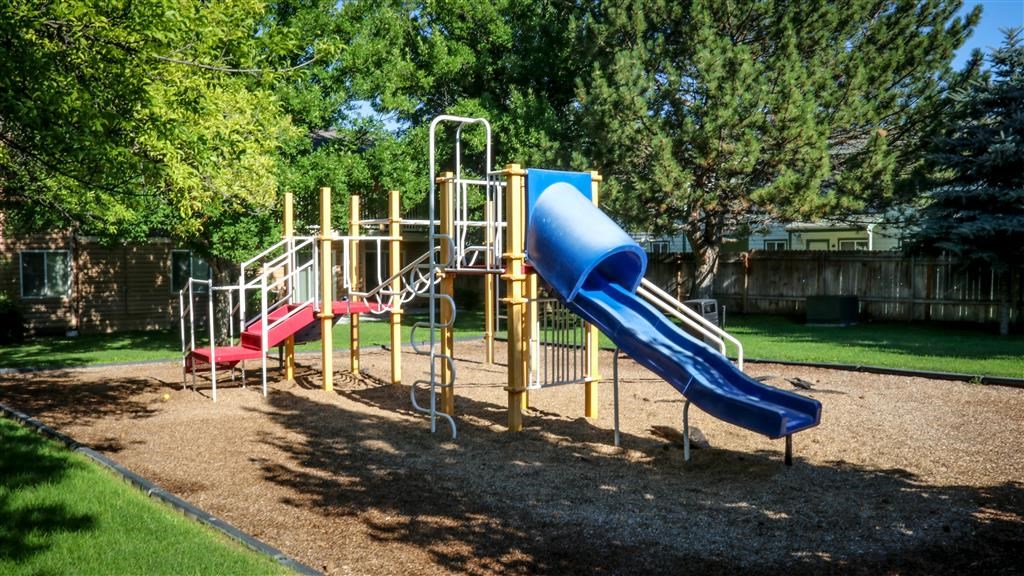 a playground with a blue slide and a red slide
