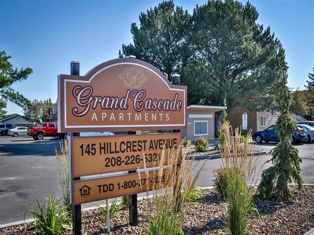 a sign for grand cascade apartments in front of a parking lot