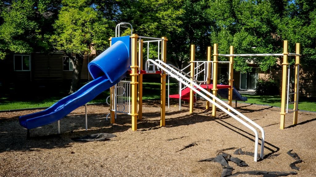 a playground with a blue slide and a red slide
