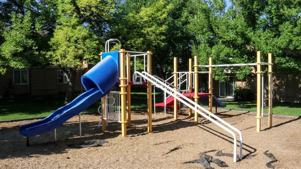 a playground with a blue slide and a red slide