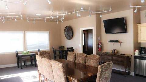 a living room with a dining room table and a television