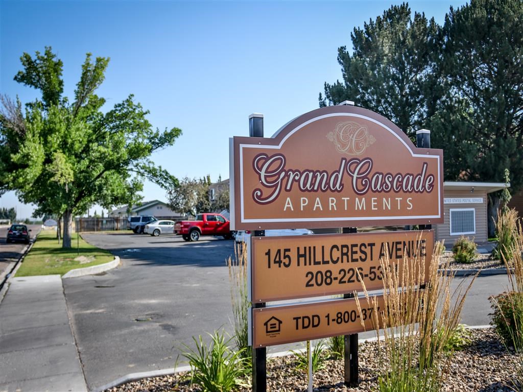 a sign for grand cascade apartments on the side of a street