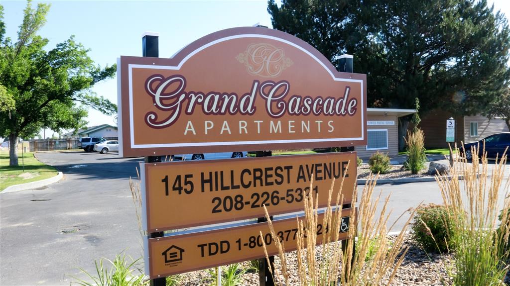 a sign for grand cascade apartments on the side of a street