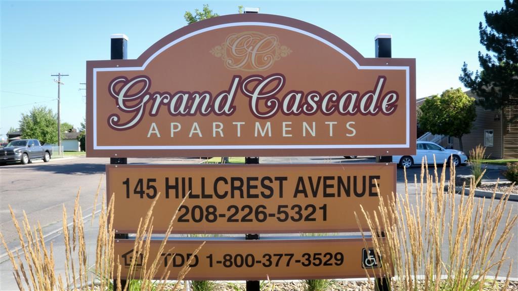 a sign for grand cascade apartments on the side of a street