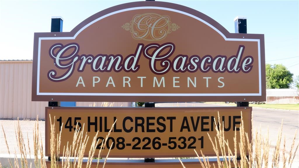 a sign for grand cascade apartments on the side of a road