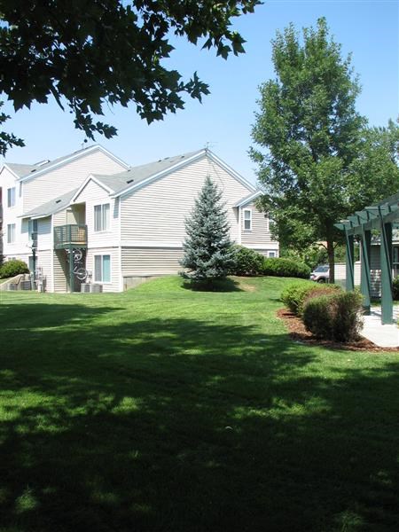 a white house with a green lawn and trees