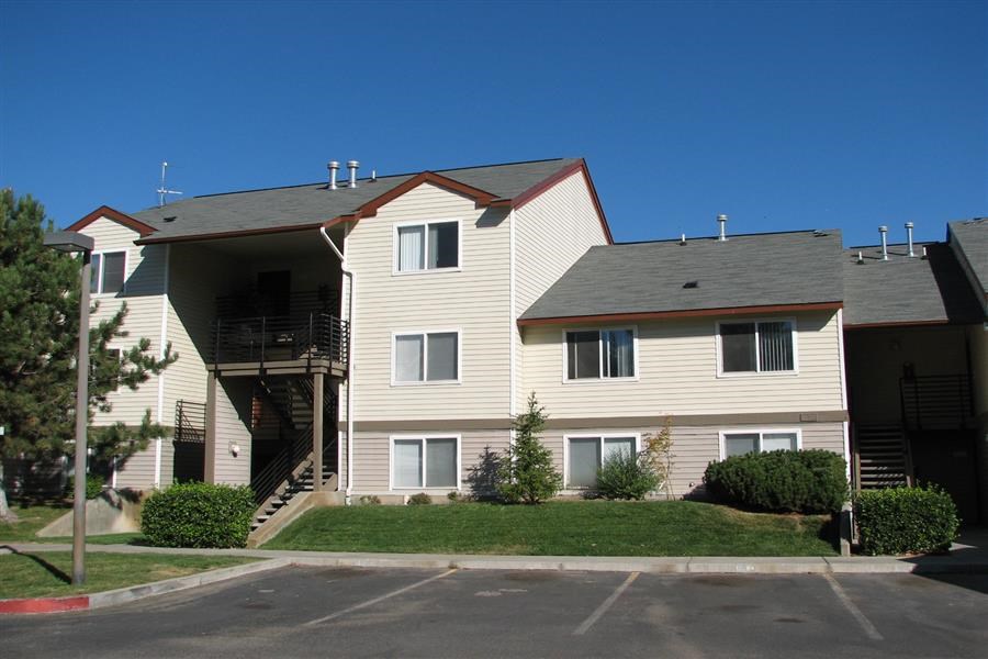 a large apartment building with a grass yard