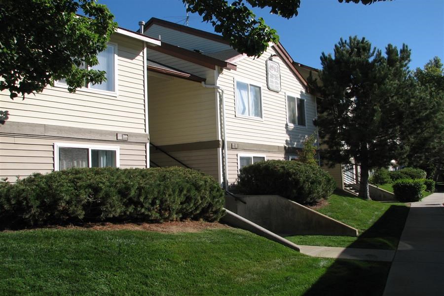a yellow house with a sidewalk in front of it