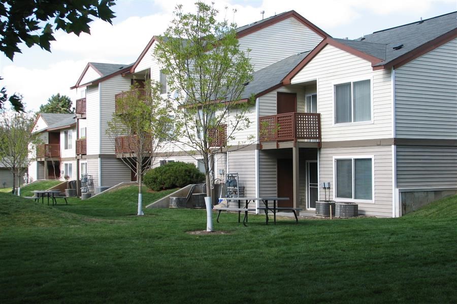 a group of houses with picnic tables in the grass