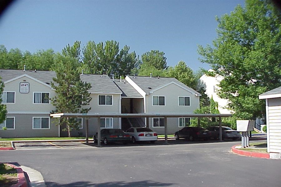 a row of houses with cars parked in a parking lot