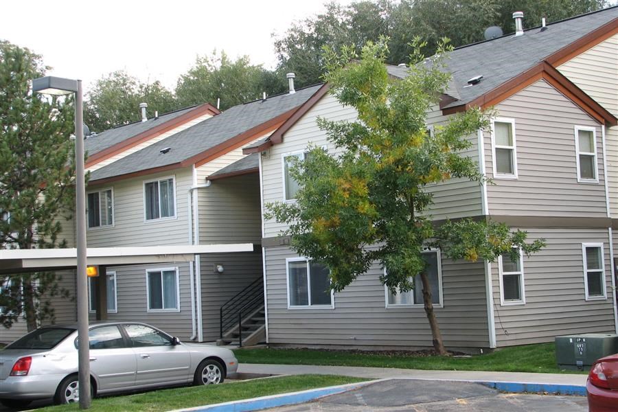 a row of houses with cars parked in front of them