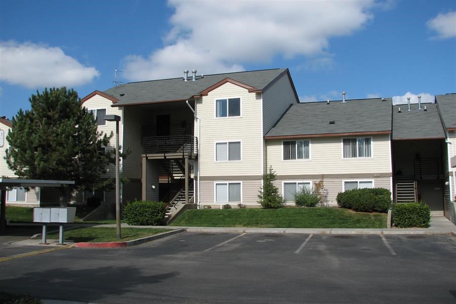 an apartment building with a parking lot in front of it