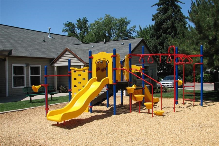 a playground with a yellow and blue swing set